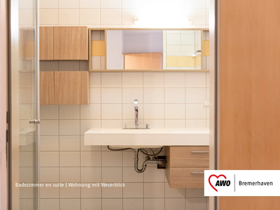 Badezimmer en suite | © AWO Bremerhaven Modernes Badezimmer mit weißem Waschbecken und Holzschränken | © AWO Bremerhaven