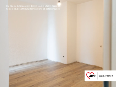 Schlafzimmer mit Bad en suite | © AWO Bremerhaven Ein leerer Raum mit weißen Wänden und einem hellen Holzboden | © AWO Bremerhaven